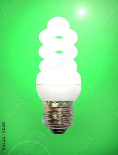 Fotografie Energy save lamp on green background.