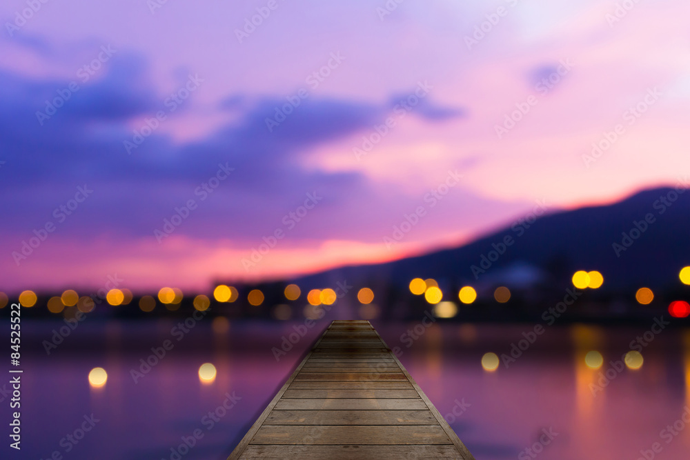 Colorful bokeh of city from the sea in night time and wooden