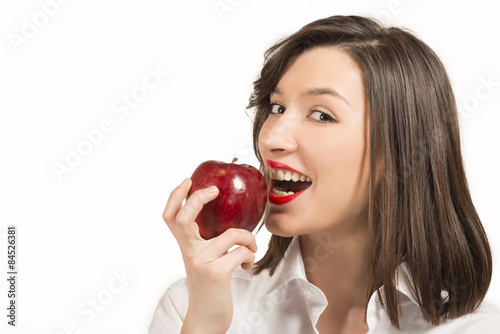 Beautiful young woman eating an red apple, studio shot on white