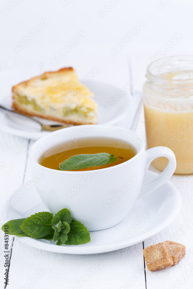 Mint tea with slice of rhubarb pie on wooden table. Mint tea with slice of rhubarb pie on wooden table.