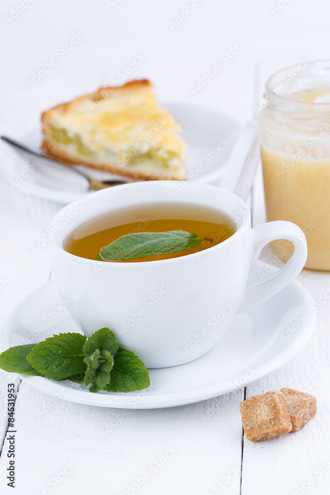 Mint tea with slice of rhubarb pie on wooden table. Mint tea with slice of rhubarb pie on wooden table.
