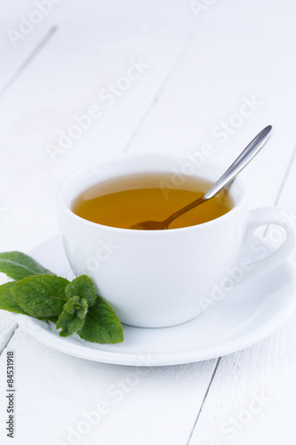 Tasty mint tea on wooden table.