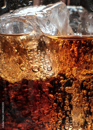 Bubbles in the glass of cola with ice.