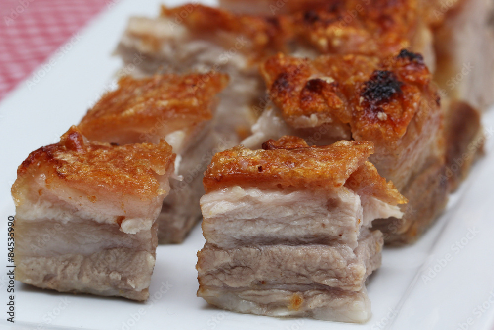 Delicious roasted pork belly cubes on white plate
