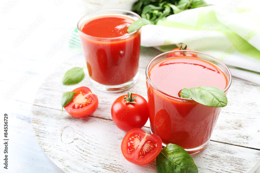 Glasses of fresh tomato juice on wooden table, closeup