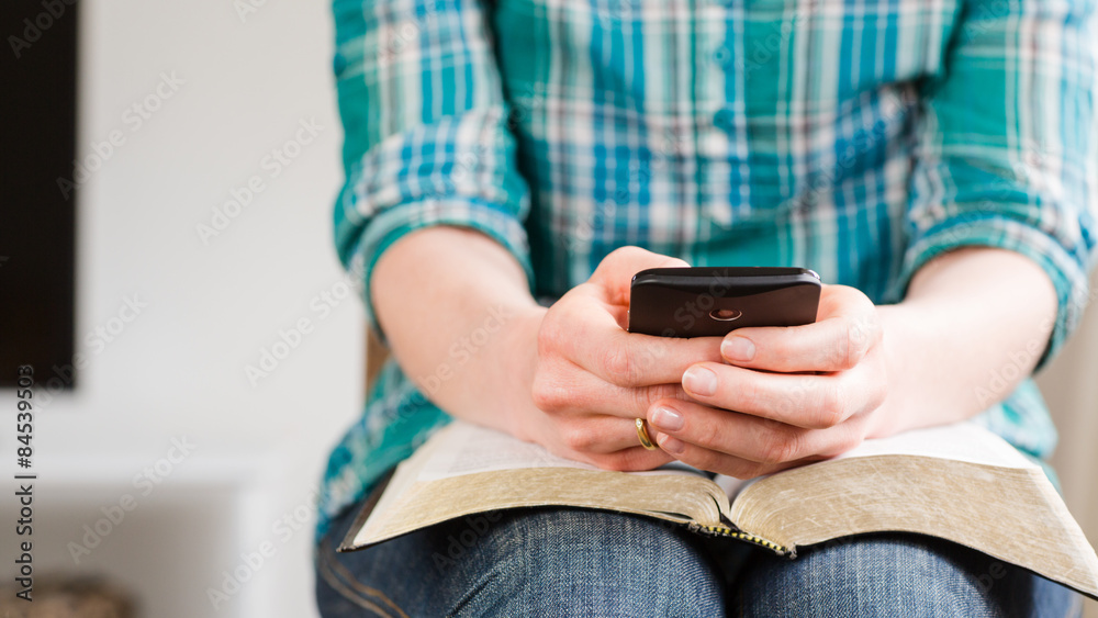 Fototapeta premium Woman with Bible and Mobile Phone