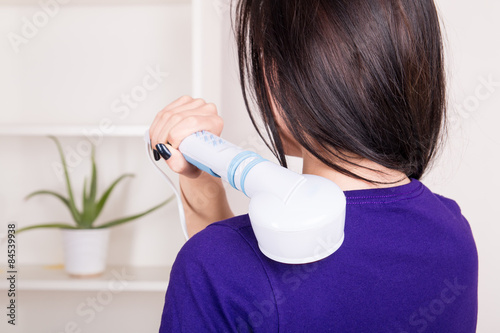 Foto Woman massaging the body with infrared lamps massager