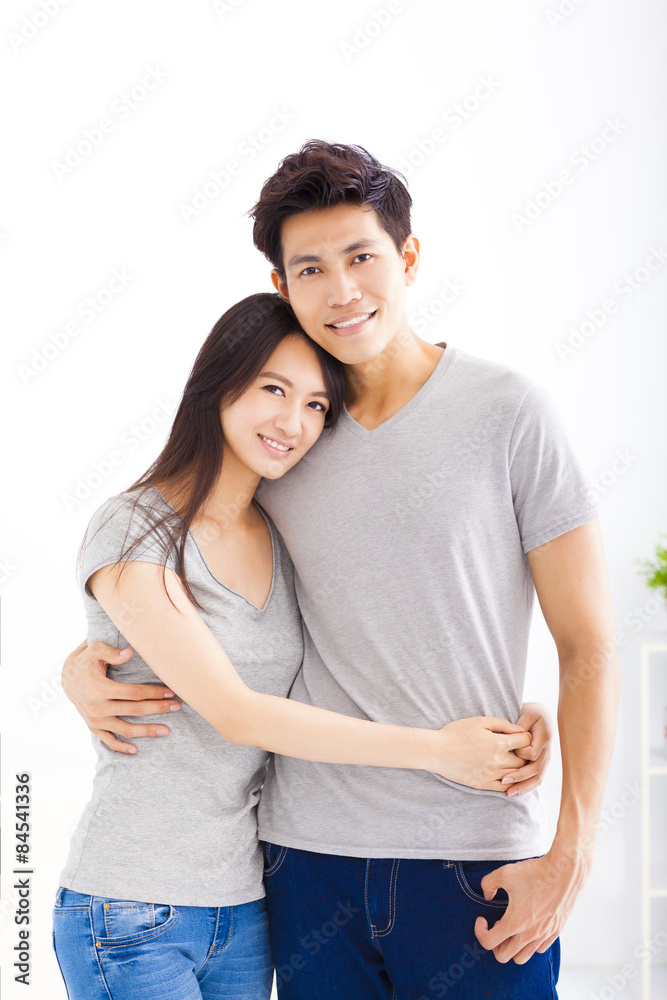 Fototapeta premium Young happy couple hugging and smiling