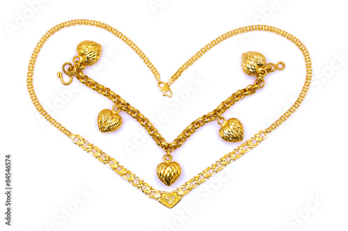 Gold necklace and bracelet in love shape over white background