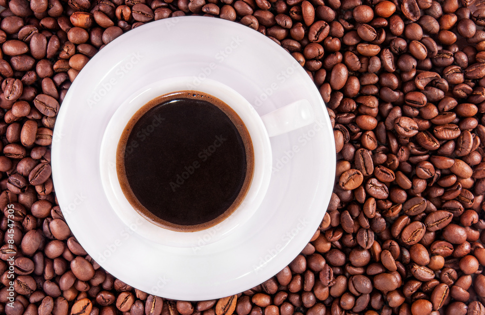 White cup of black coffee on a beans background White cup of black coffee on a beans background