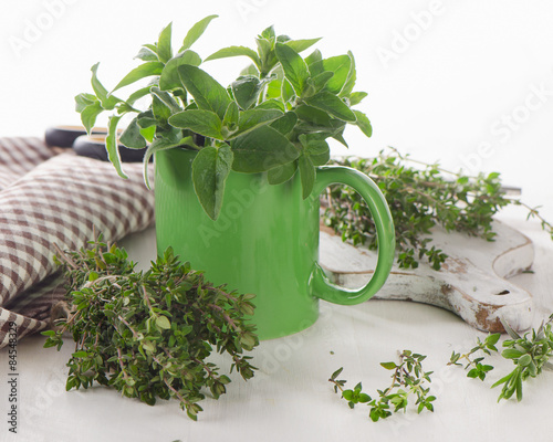 Fresh herbs on  white cutting board.