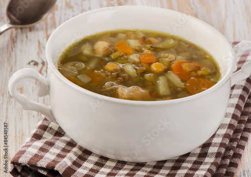 White Bowl of Soup with Lentils, Beans, Chicken and Vegetables.