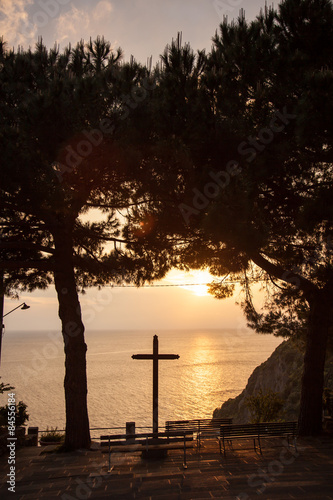 Kreuz im Gegenlicht der Untergehende Sonne am Meer in Riomagiore photo