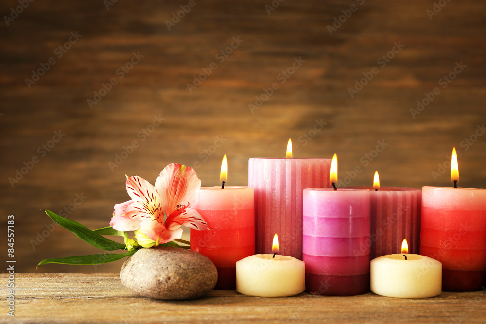 Beautiful composition with candles and spa stones on wooden background Beautiful composition with candles and spa stones on wooden background