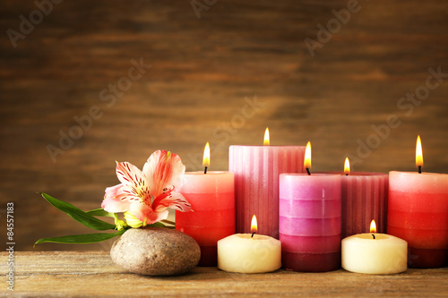 Beautiful composition with candles and spa stones on wooden background