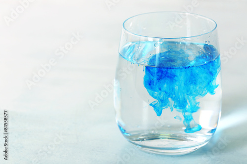 Wallpaper Mural Glass of water with blue paint on table close up Torontodigital.ca