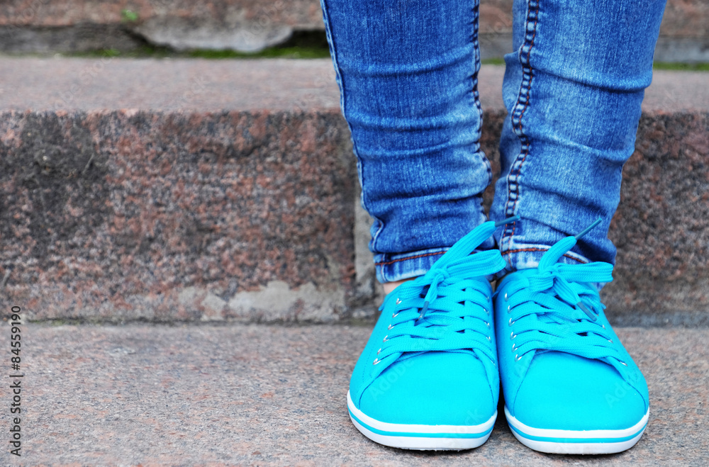 Female feet in gumshoes on  stone stairs