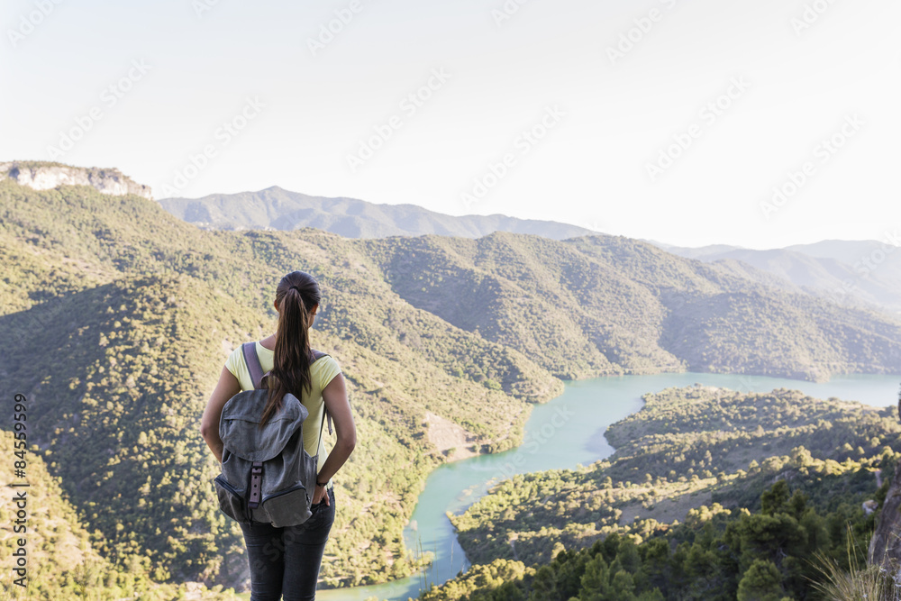 Naklejka premium young woman on top of a mountain with good views