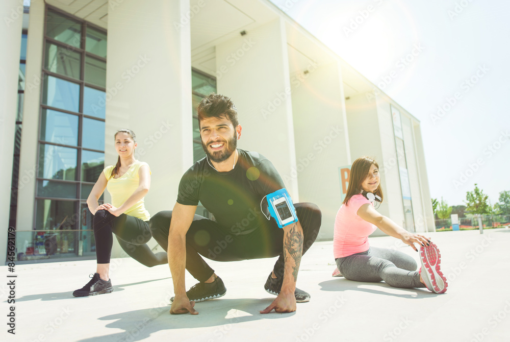 Obraz premium three urban runners preparing with stretching