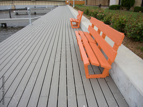Orange park benches provide a place to rest on a river walk.