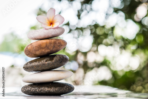 zen stones with frangipani flower on bokeh background