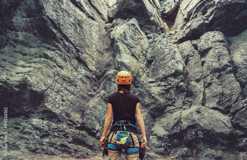 Billede på lærred Climber woman standing in front of a stone rock outdoor