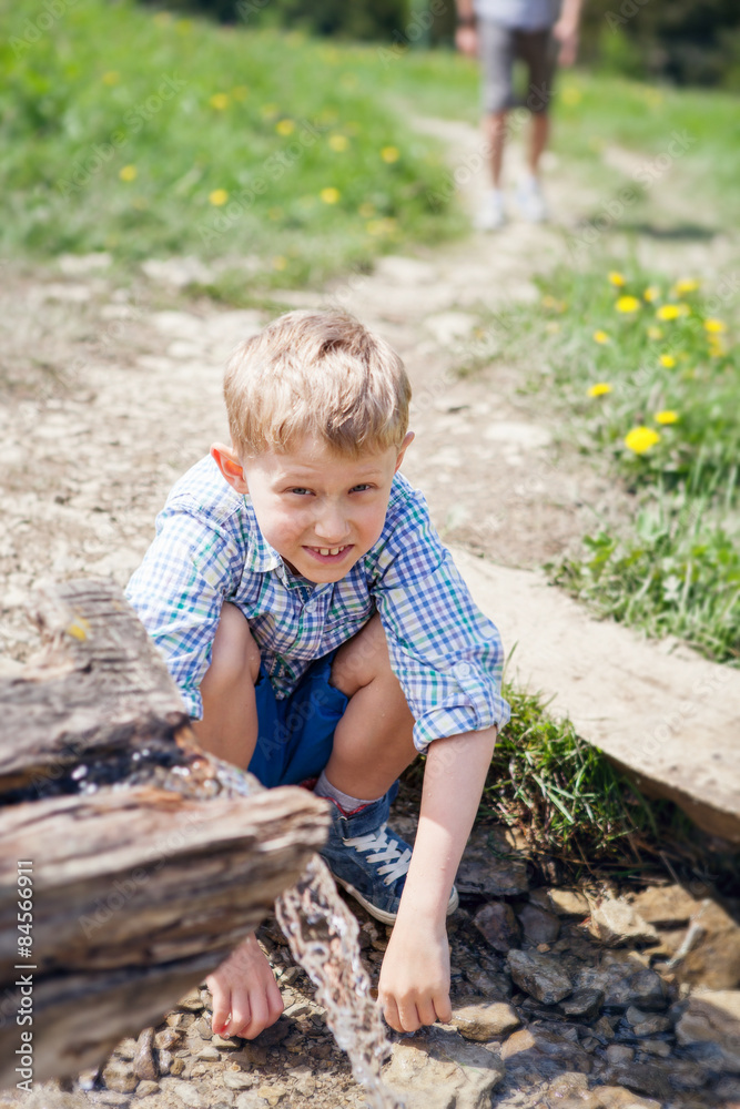 Little boy near clear mountain stream Little boy near clear mountain stream