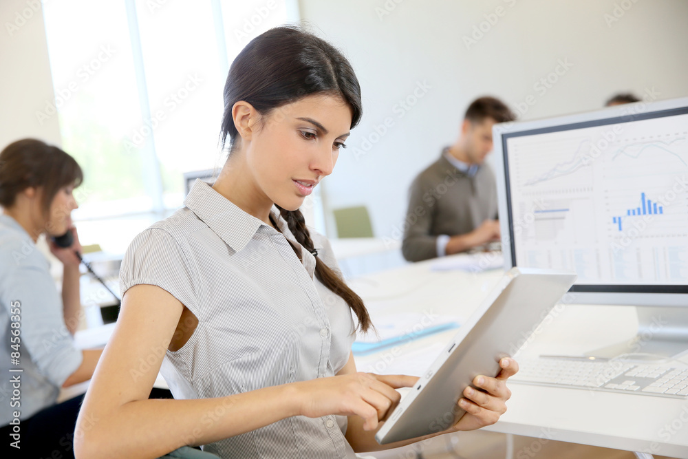 Young business girl working on digital tablet in office Young business girl working on digital tablet in office