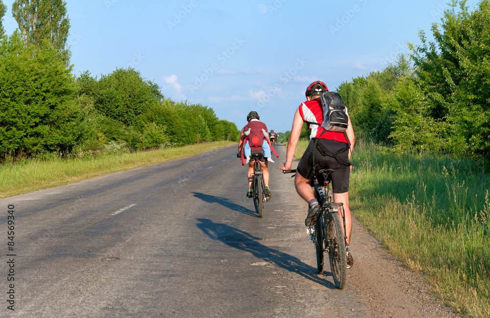 Naklejka premium Group of tourists mountain bike ride on dirt road. 