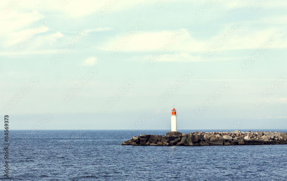 Vintage colorized picture of white lighthouse and stone pier 