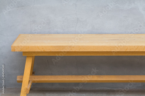 Brown wood bench and concrete wall background