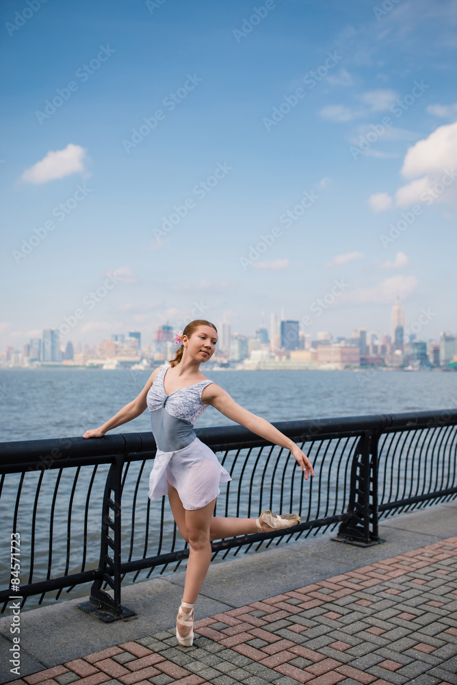 Young beautiful ballerina dancing along the New Jersey waterfront. New York.
