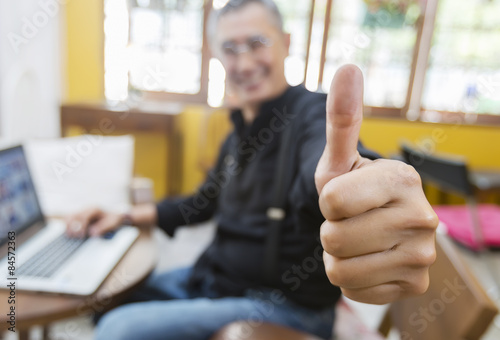 businessman showing thumbs up to camera photo