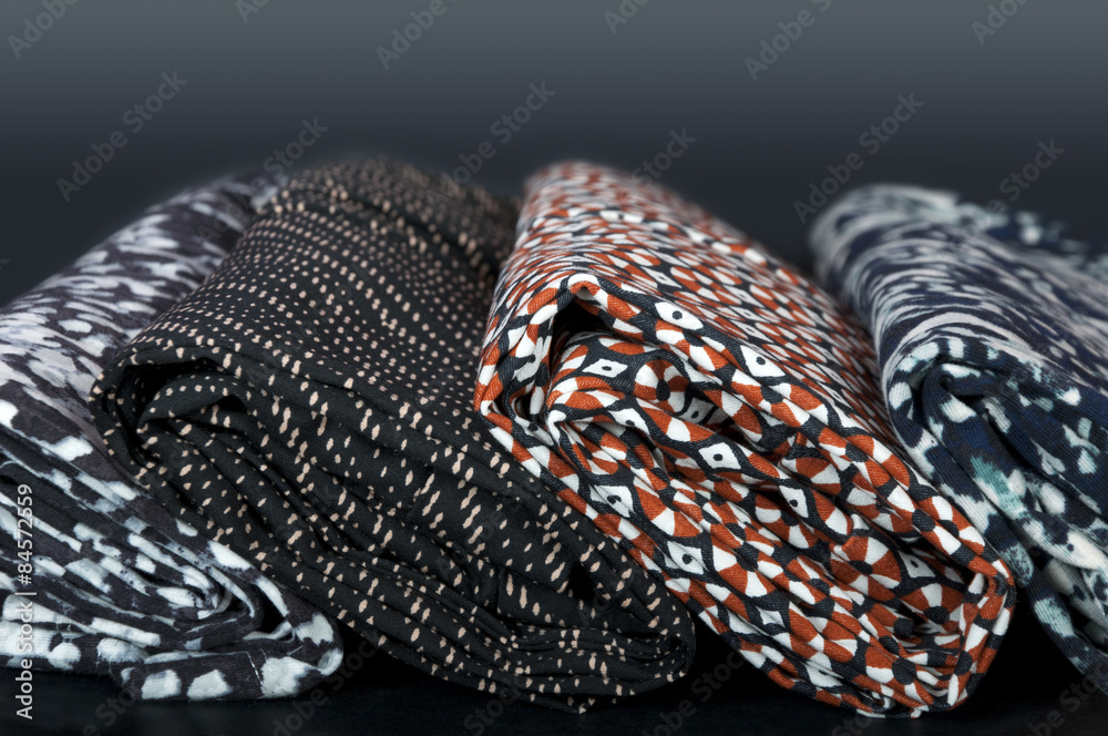 rolls of different fabrics on black background rolls of different fabrics on black background