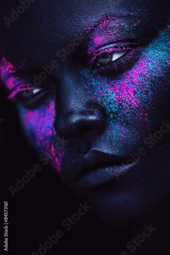 portrait of woman in black paint and neon powder