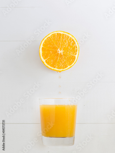 Orange dripping juice over a orange juice glass