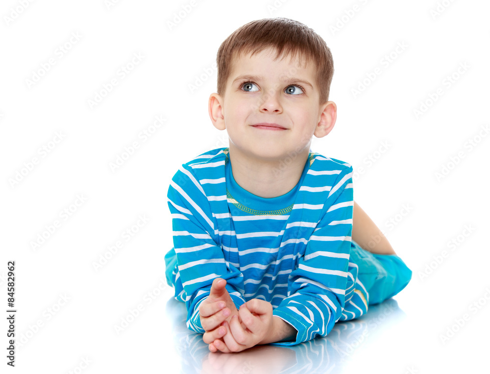 Beautiful little boy lying on the floor and dreams Beautiful little boy lying on the floor and dreams