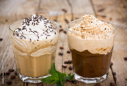 Two glasses of ice coffee with milk and whipped cream