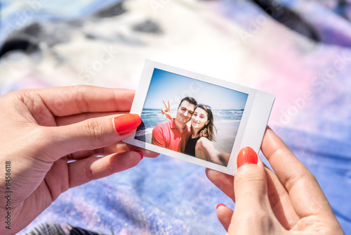 Girl Holding Instant Photo Of Young Happy Couple