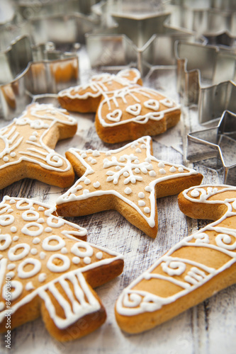 Christmas gingerbread cookies and metal cookie cutters on white