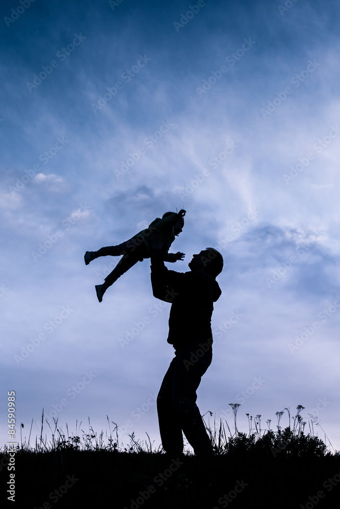 silhouette of father with baby flying over his head silhouette of father with baby flying over his head