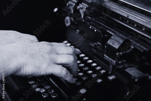 ugly hands typing on a vintage typewriter