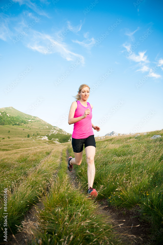 beautiful young woman runns cross country on a mountian path at beautiful young woman runns cross country on a mountian path at