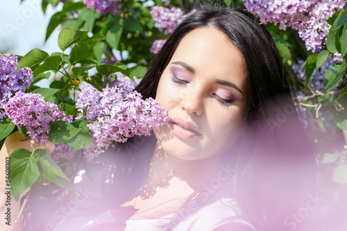 beautiful young girl near the lilac, beautiful purple flowers. warm summer day photo