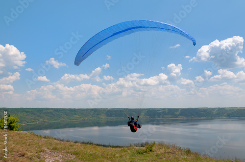 Paraglider above Bakota beautiful reservoir in the clouds