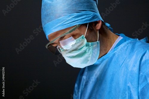 Man surgeon holds a scalpel in an operating room photo