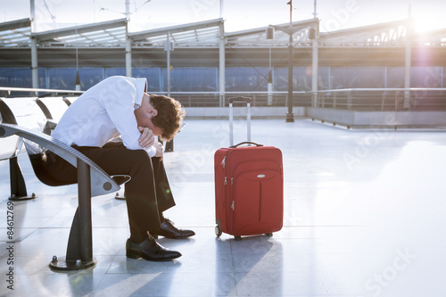 Businessman in working on laptop in airport waiting lounge