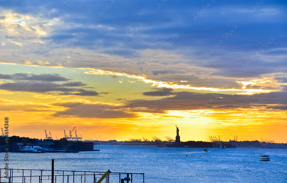 View of Statue of Liberty at sunset in New York. 