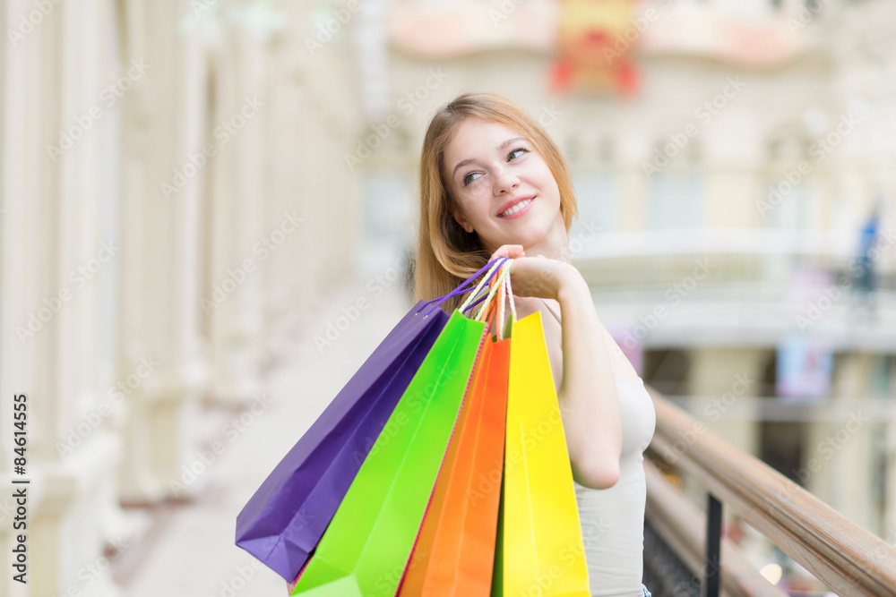 A happy smiling young lady with a lot of colourful shopping bags from the fancy shops. A happy smiling young lady with a lot of colourful shopping bags from the fancy shops.