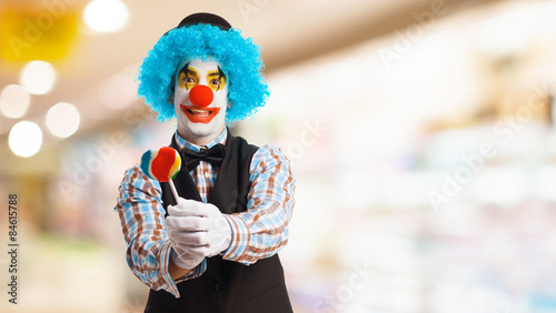 Obraz na plátne portrait of a funny clown holding a lollipop